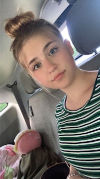 a young girl sitting in the back seat of a car